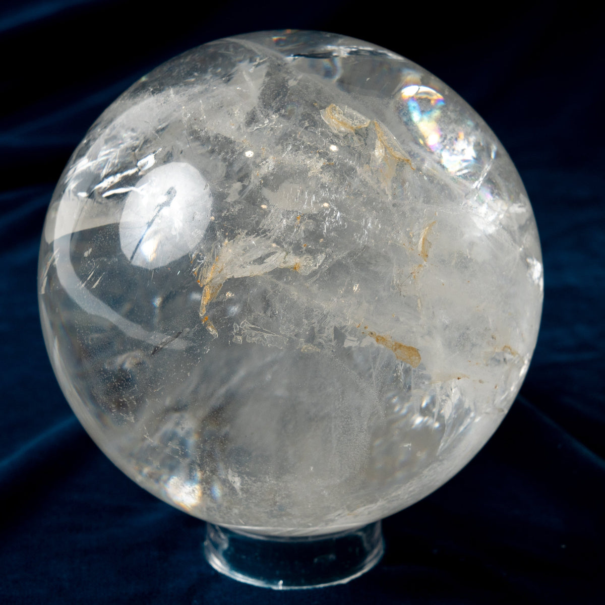 Clear crystal sphere on a dark blue fabric background