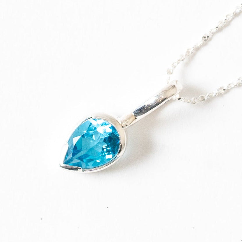 Necklace with a blue Topaz teardrop pendant on a white background