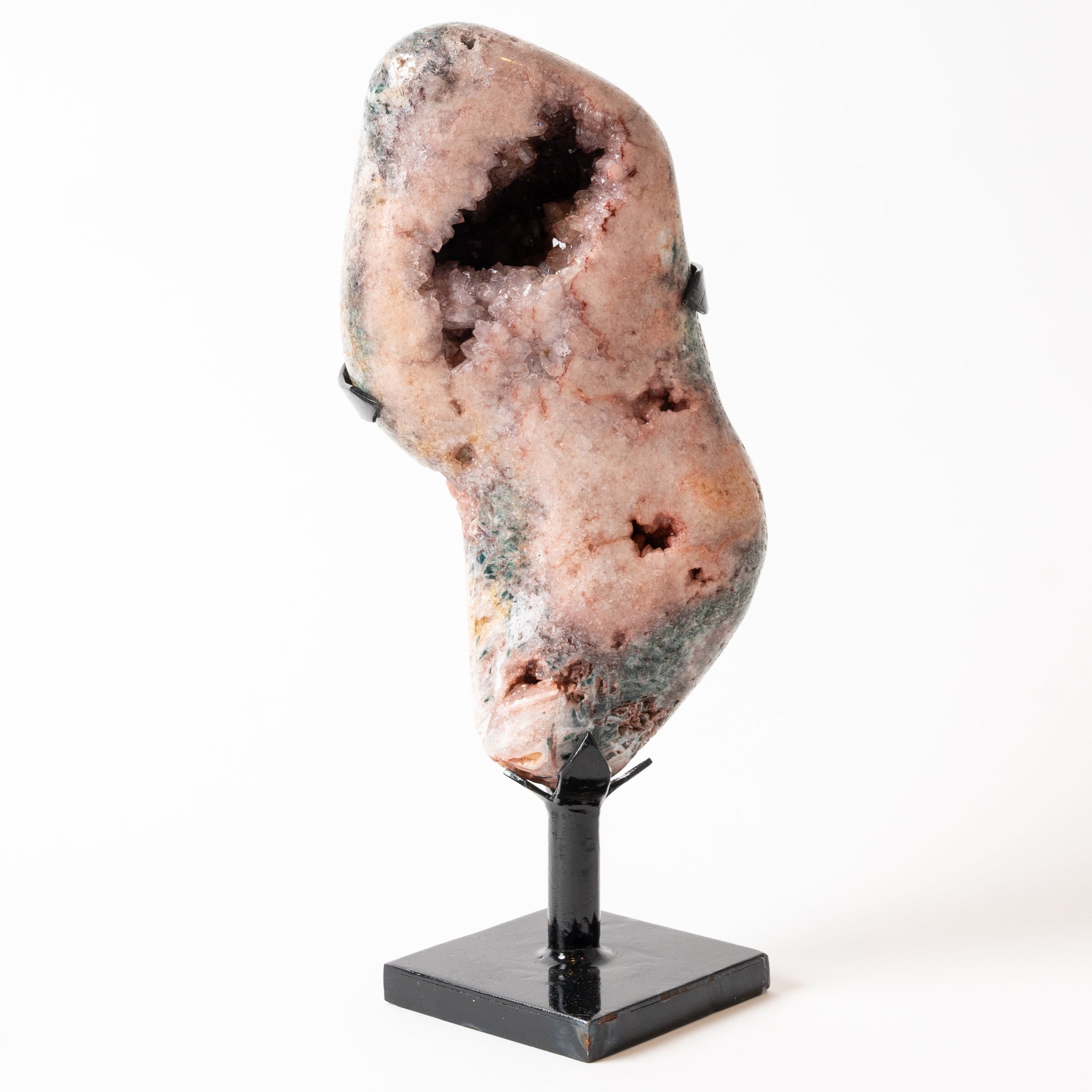 Pink Amethyst Geode crystal on a stand against a white background
