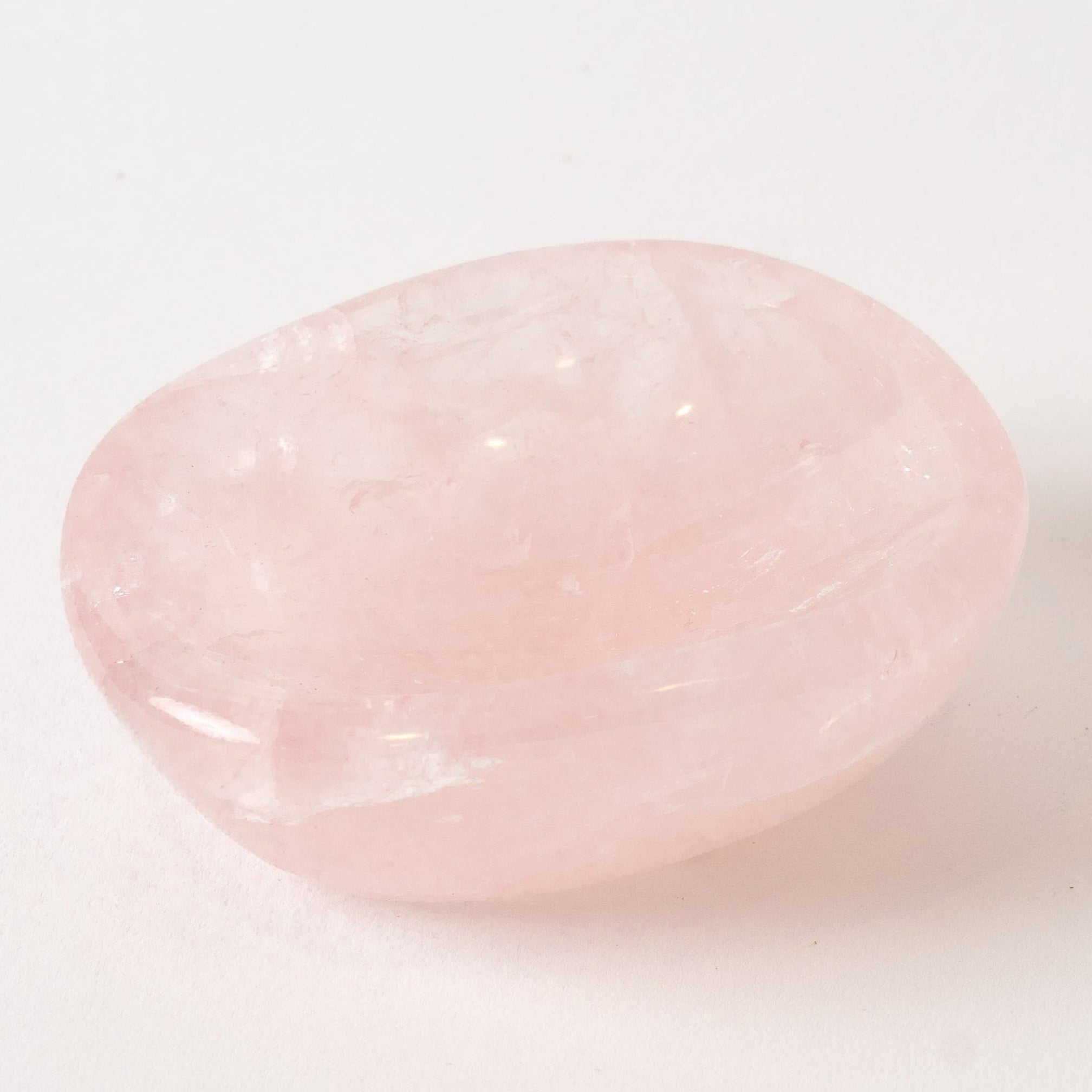 Pink rose quartz stone bowl on a white background