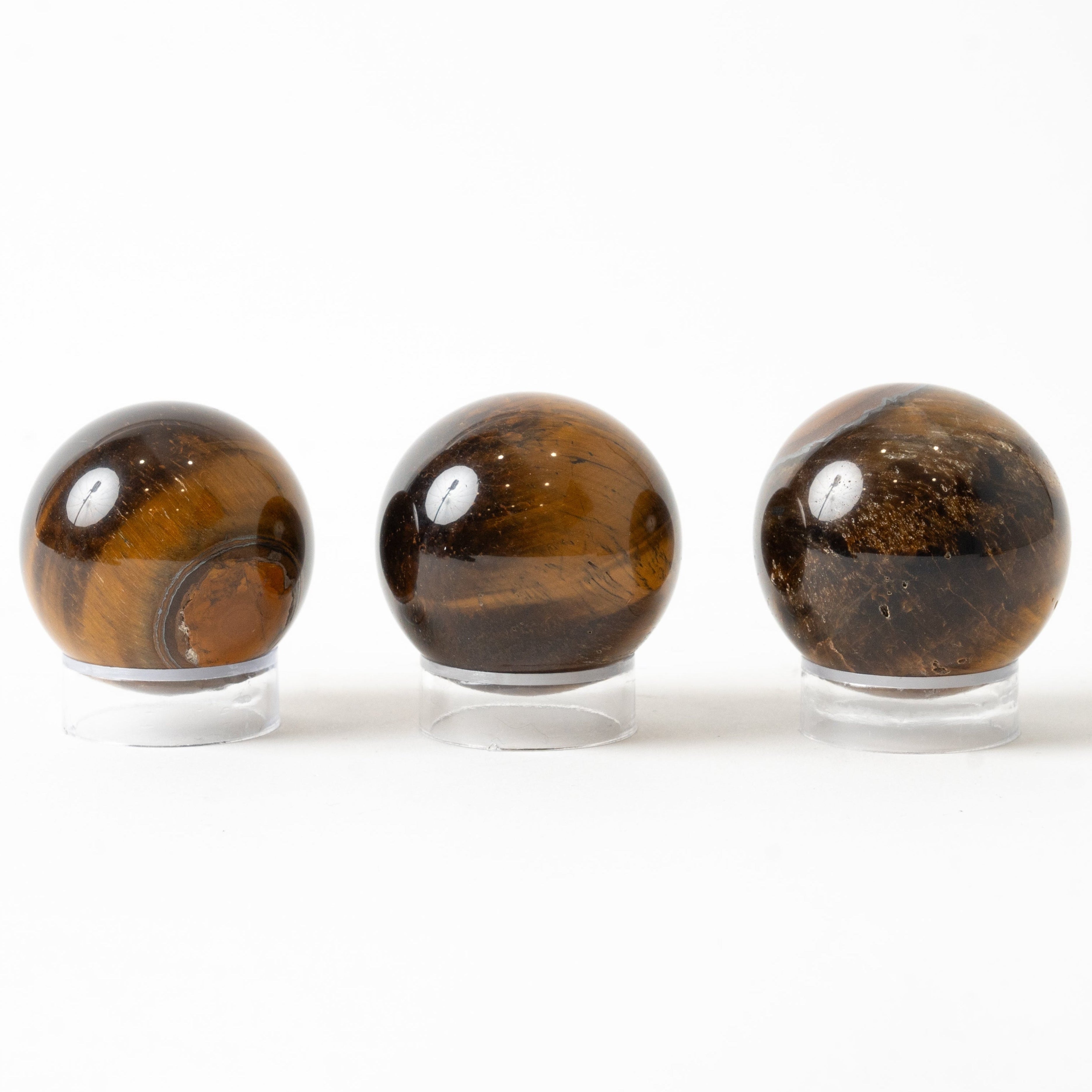 Three tiger eye stones on a white background