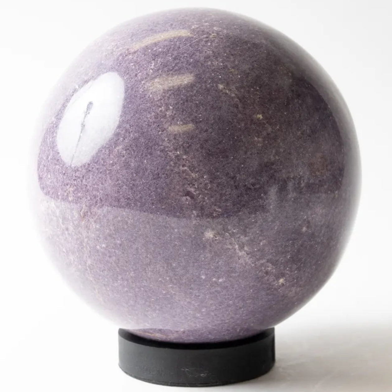 Purple stone lepidolite sphere on a white background