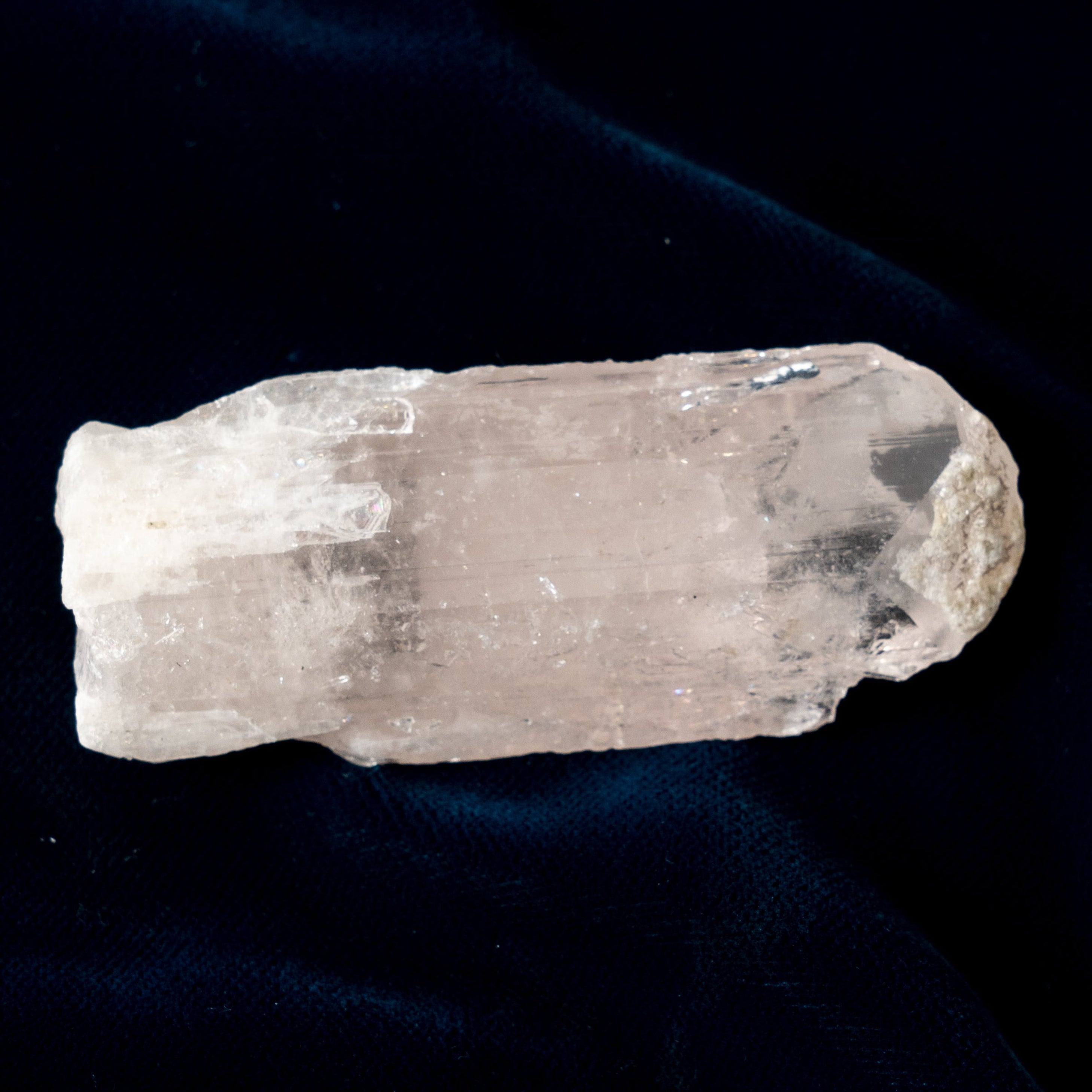 Danburite Crystal on a dark blue fabric background