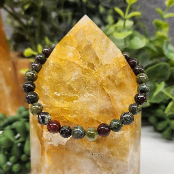 Dragon Bloodstone 6mm Smooth Bead Stretch Bracelet on stone display
