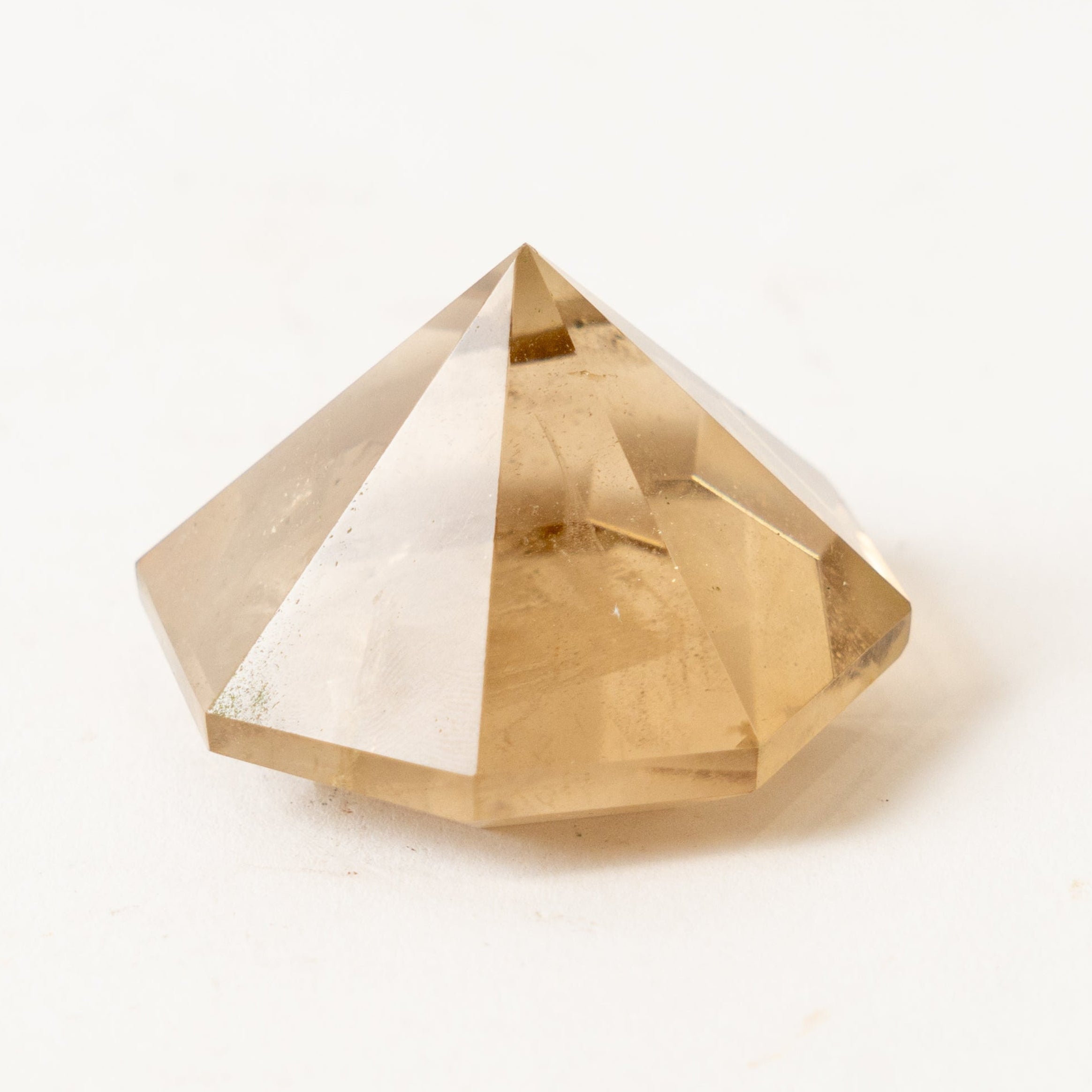 Faceted smoky quartz crystal on a white background