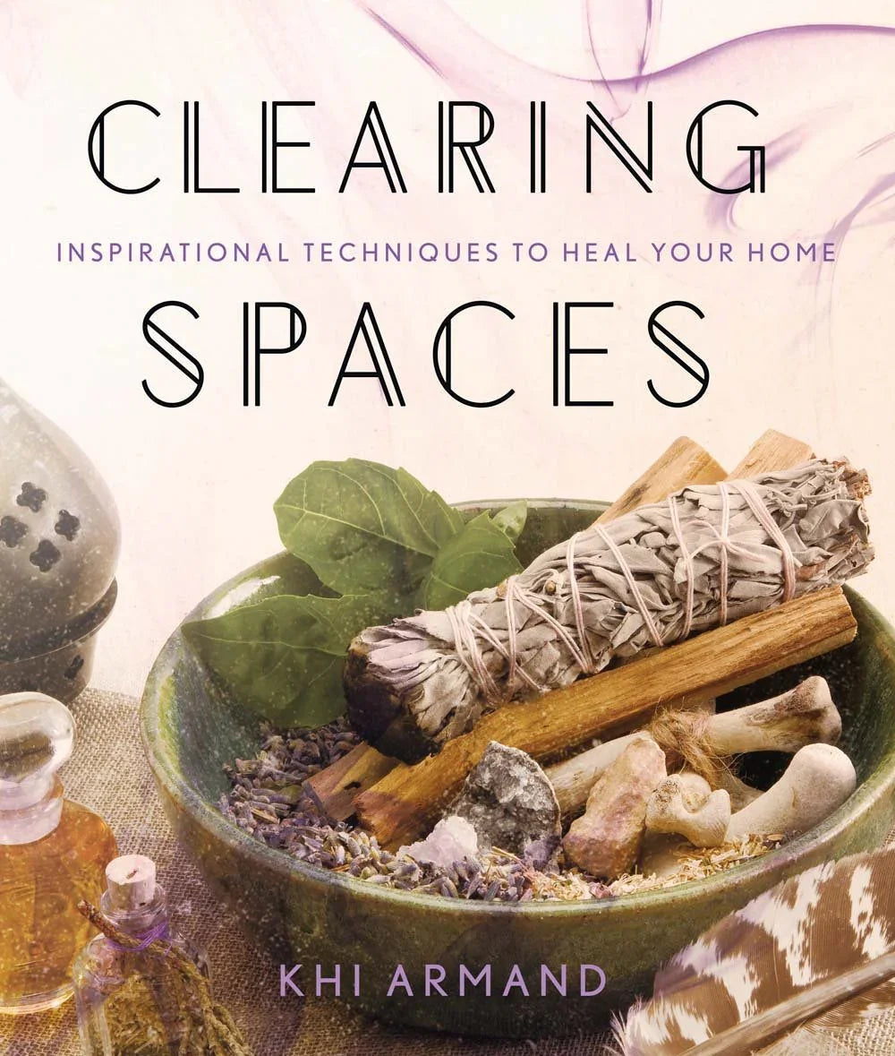 Book cover of 'Clearing Spaces' with a bowl of herbs and smudging sticks.