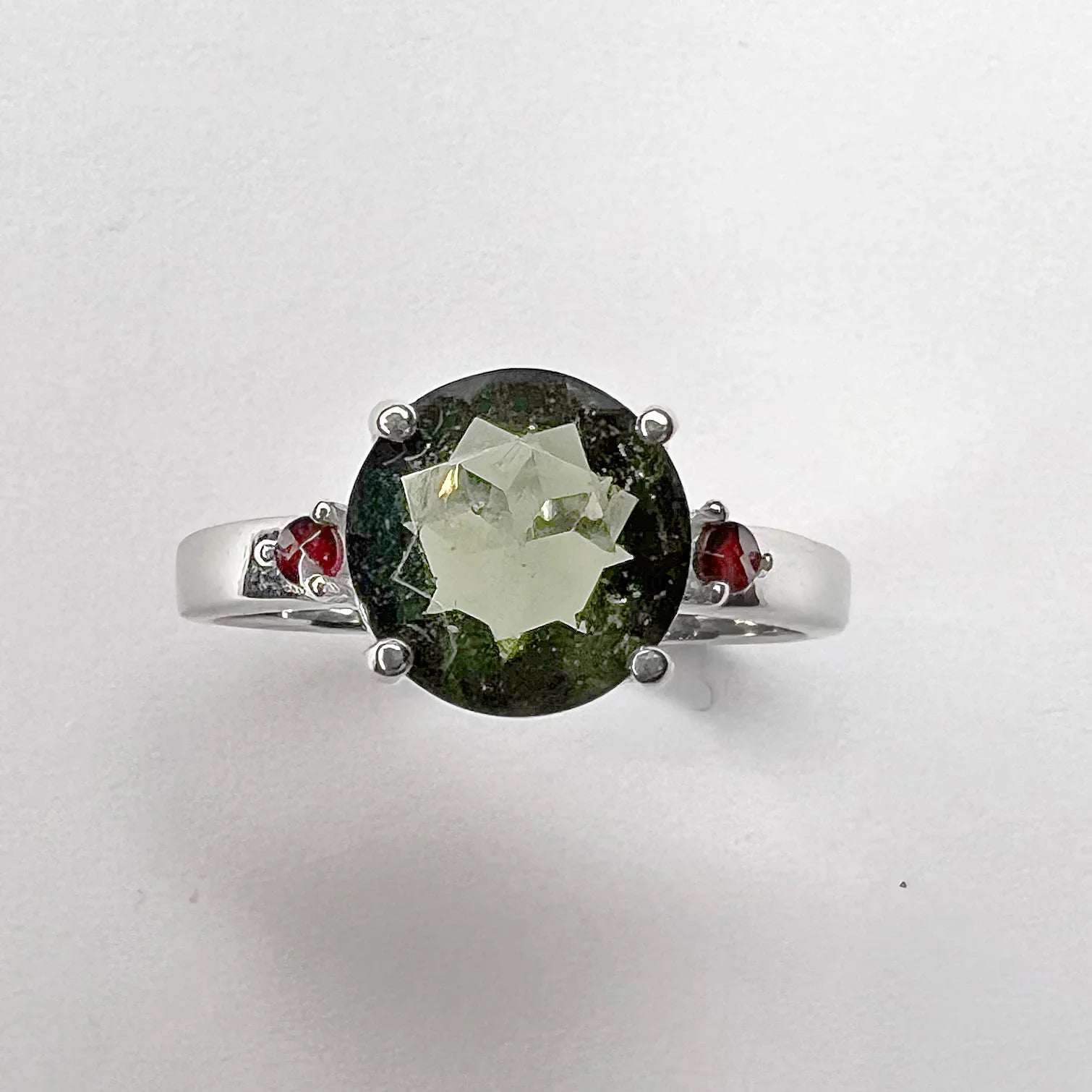 Moldavite Faceted Oval Ring with Garnet Accents front view