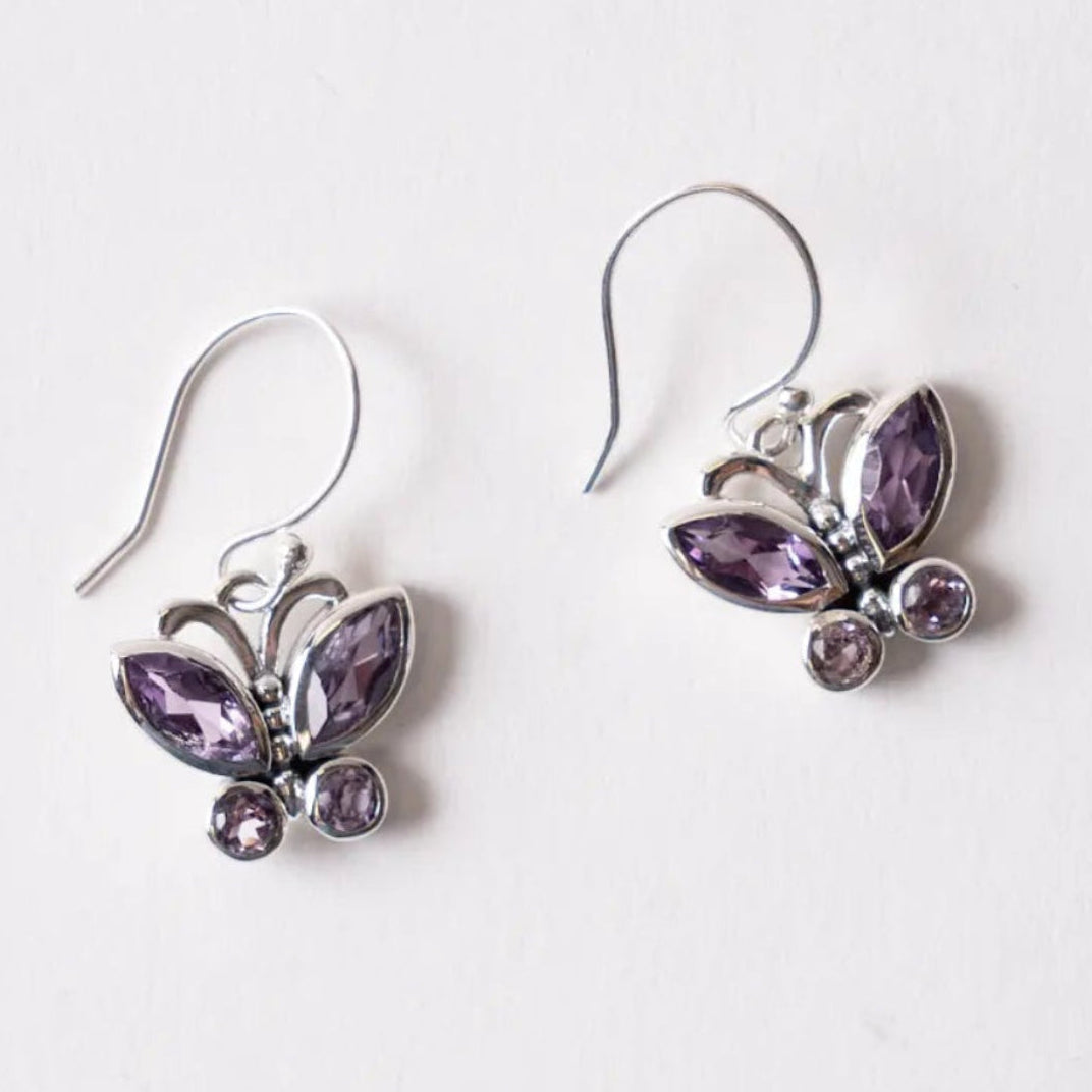 Butterfly-shaped earrings with purple Amethyst gemstones on a white background
