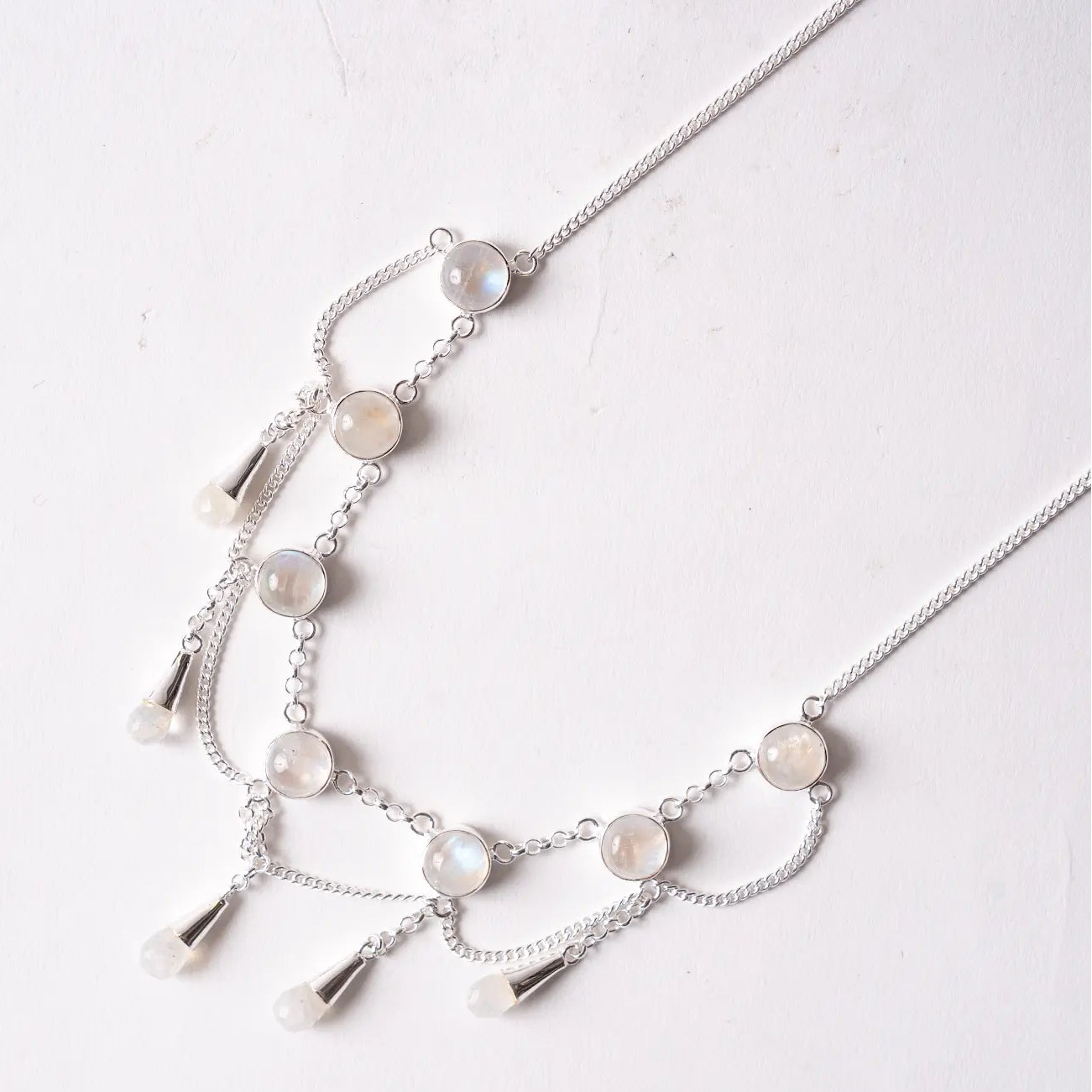 Silver necklace with moonstone beads on a light background