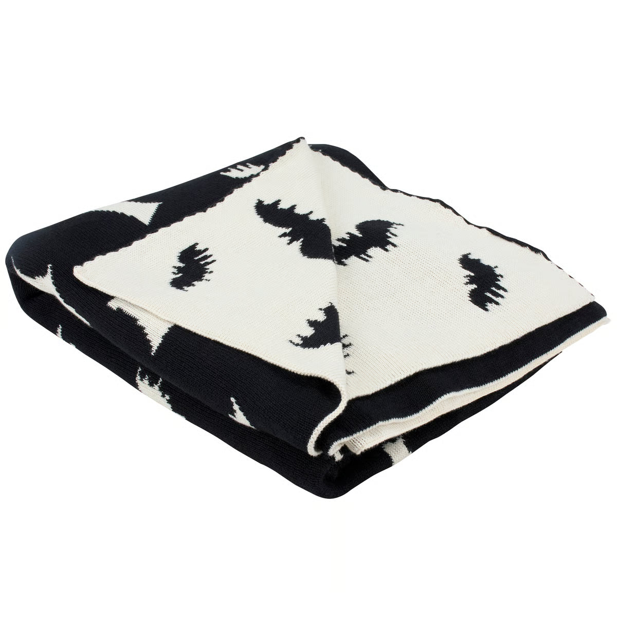 A folded knit blanket featuring a black and off-white pattern of stylized bats and abstract shapes, shown on a plain white background.