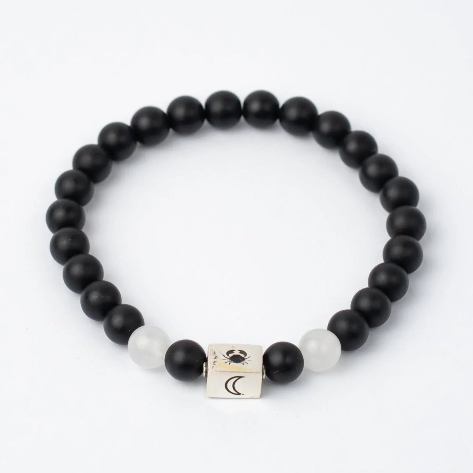 Black beaded Cancer Sun Sign bracelet with a silver cube charm on a white background