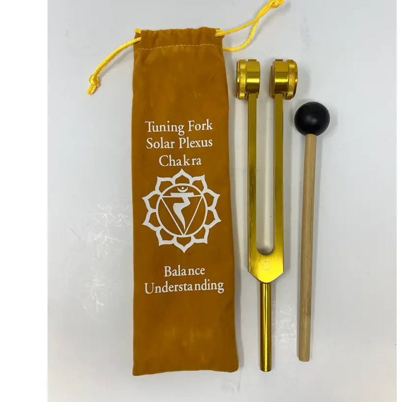 Yello Tuning fork with chakra symbol and velvet pouch on a white background
