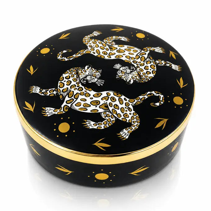 A round black lacquered box with a lid featuring two white and gold leopard illustrations, accented with gold leaf motifs and a gold band around the rim.