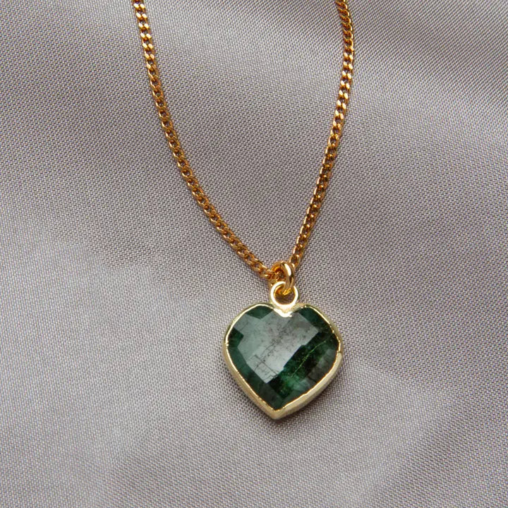 Necklace with a green heart-shaped pendant on a gray background