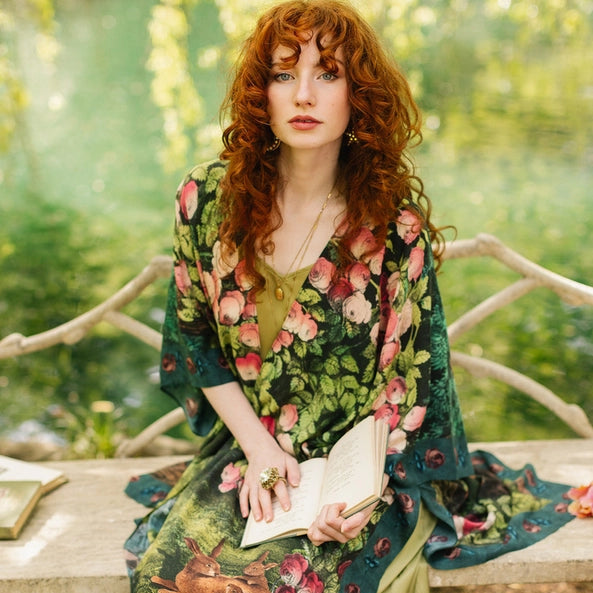 Woman in a floral dress sitting outdoors with a blurred natural background