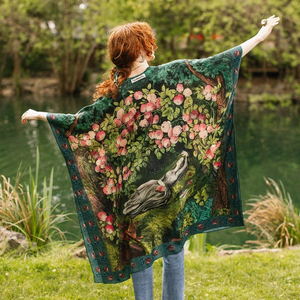 Person wearing a floral patterned shawl by a body of water