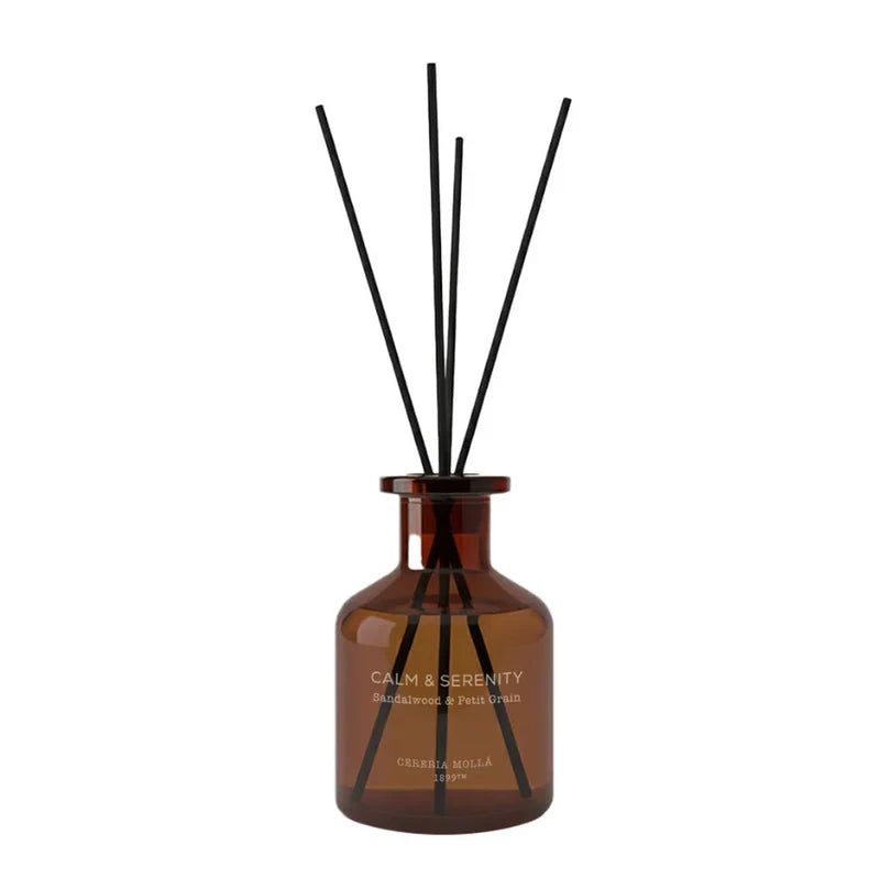 Amber glass reed diffuser bottle with black reeds, labeled 'CALM & SERENITY'