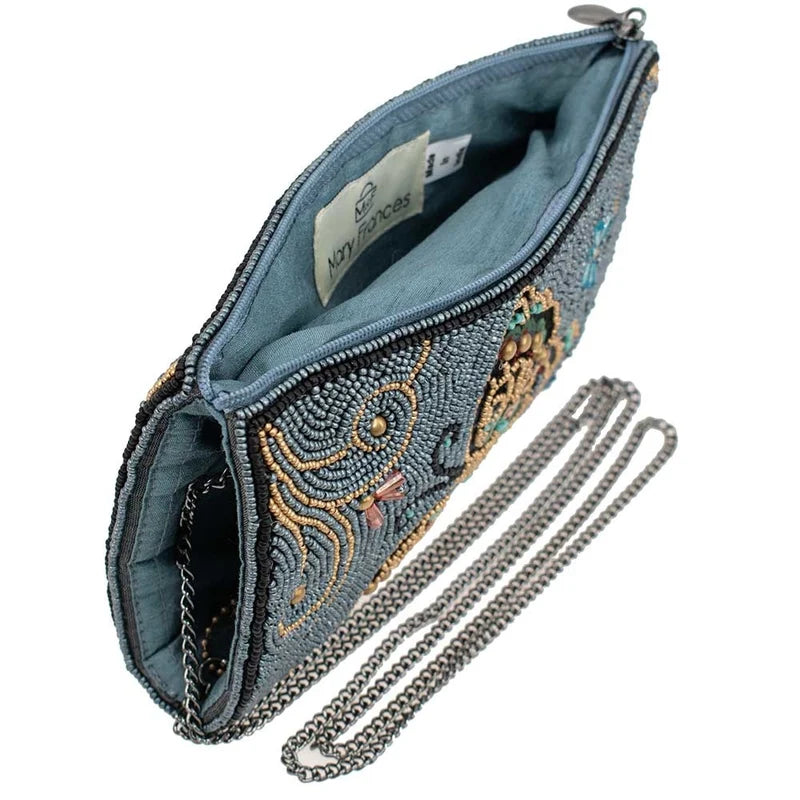 Blue embroidered clutch with a chain strap on a white background
