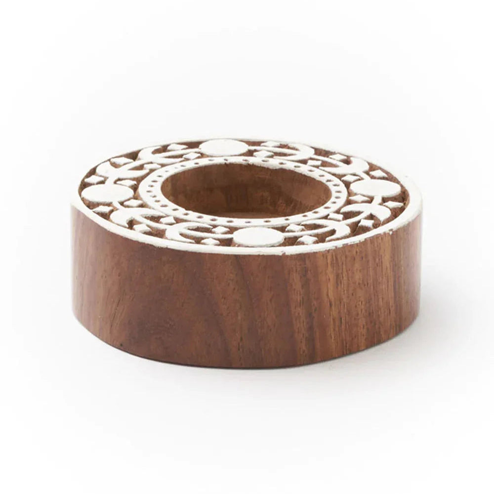 Wooden candle holder with intricate carvings on a white background