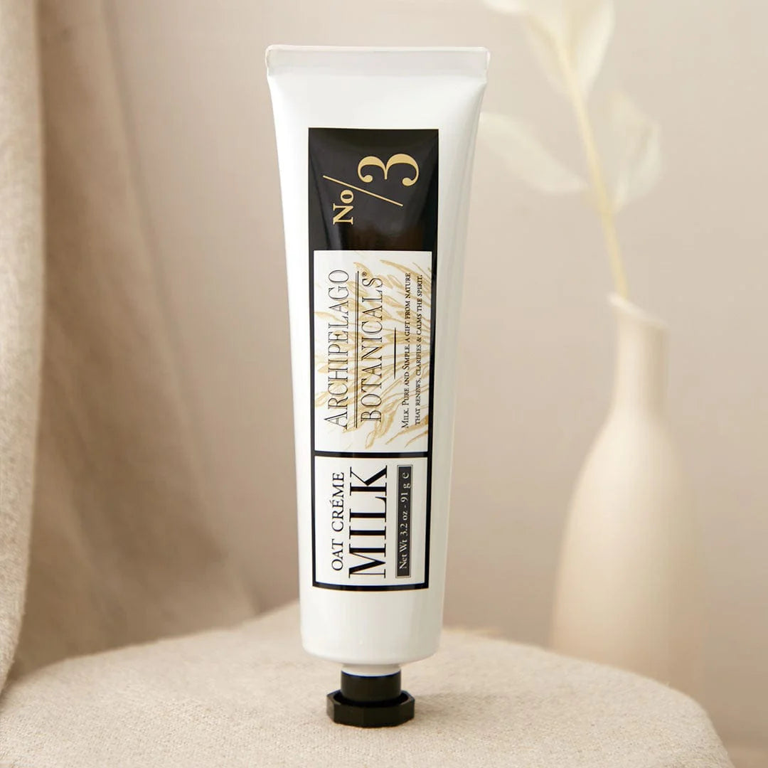 Tube of Archipelago Botanicals Oat Creme Milk on a beige surface