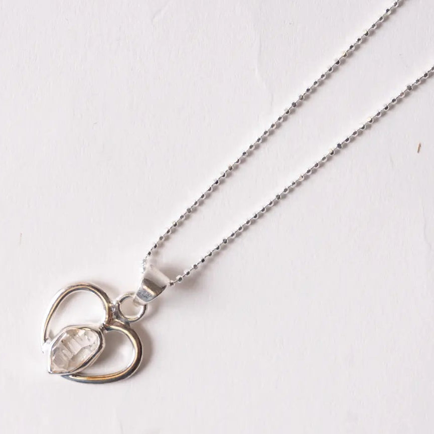 Silver herkimer diamondnecklace with a heart-shaped pendant on a white background