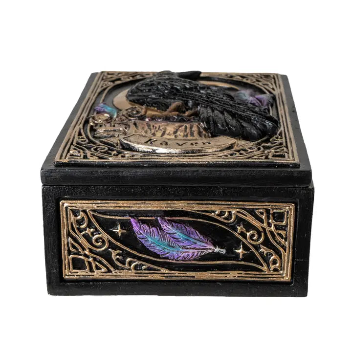 Decorative box with raven and feather design on a white background