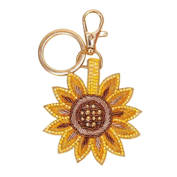 Sunflower-shaped keychain with gold and bronze details on a white background