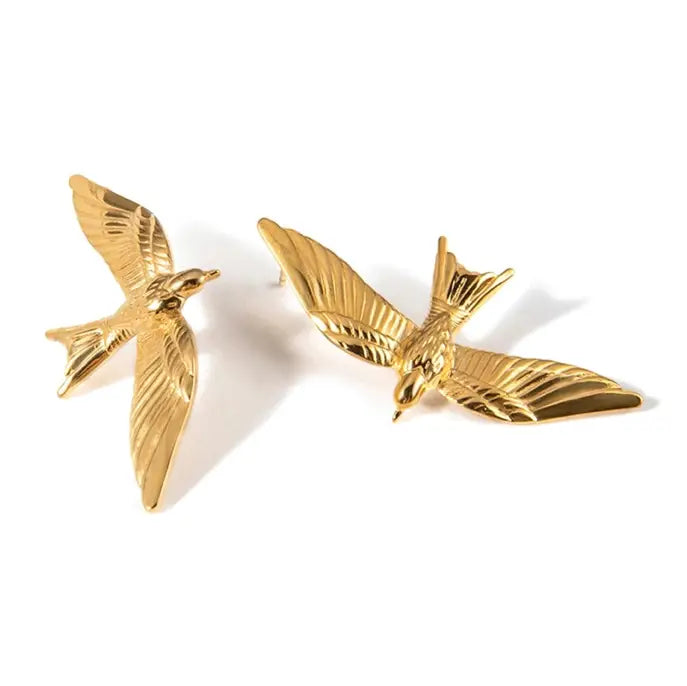 A pair of gold bird stud earrings shaped like flying birds with detailed feather textures, shown on a clean white background.