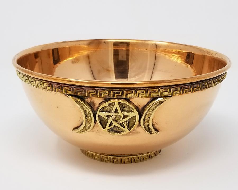 Copper bowl with pentacle and moon designs on a white background