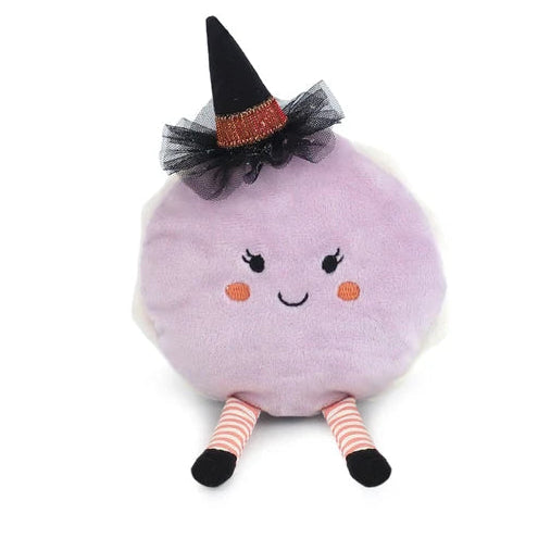 A cute, round lavender macaron plush toy styled with a witch hat with a smiling face, wearing a black witch hat with a black tulle sash and orange glitter band, and striped pink and white legs.