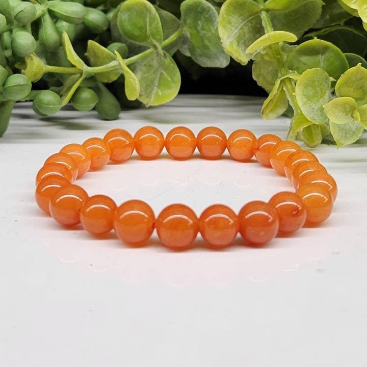 Calcite Orange 6mm Smooth Bead Stretch Bracelet on white background