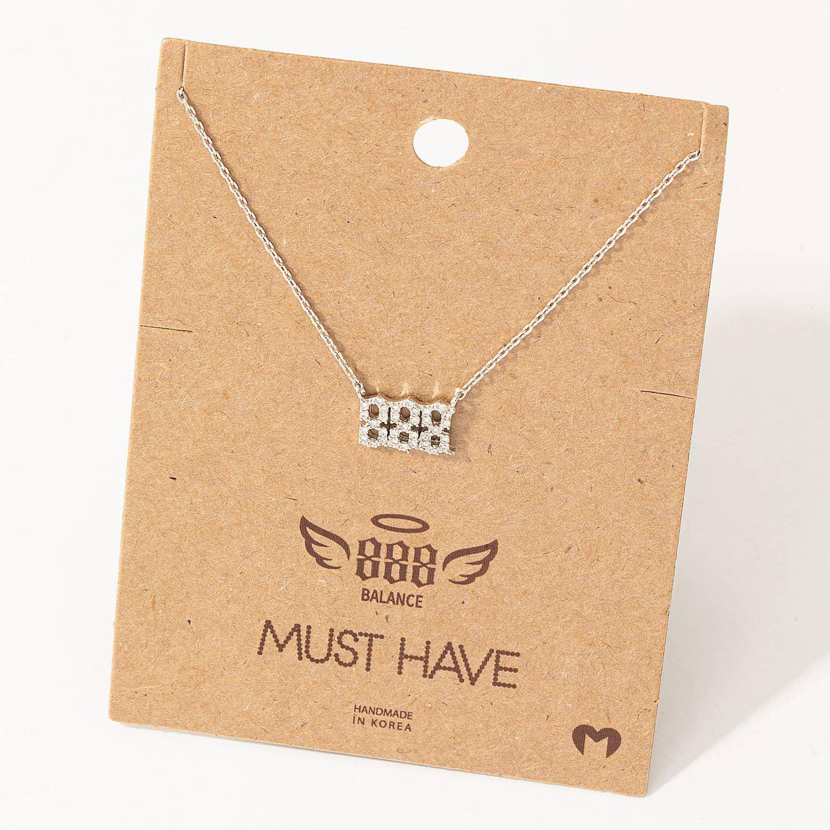 Silver necklace on a brown cardboard card with branding