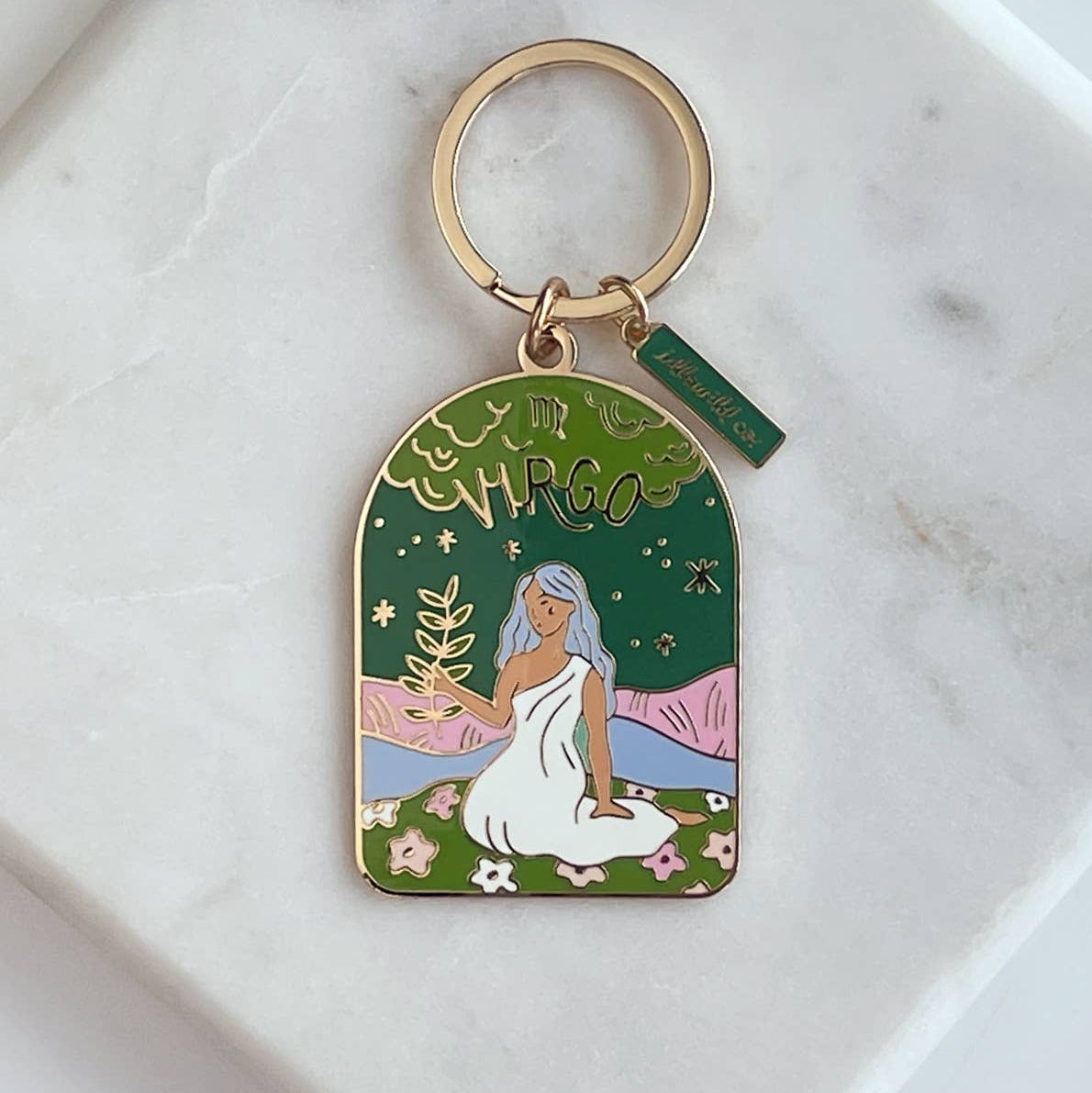 Keychain with a design of a woman in a white dress and a deer, on a green background.