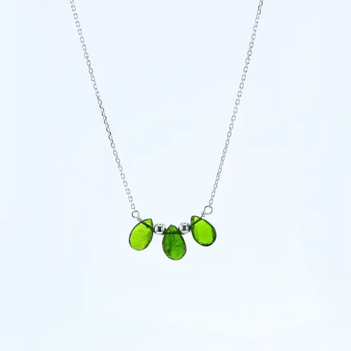 A silver chain necklace featuring three green tourgemstone beads in a small cluster pendant, set against a plain white background.aline