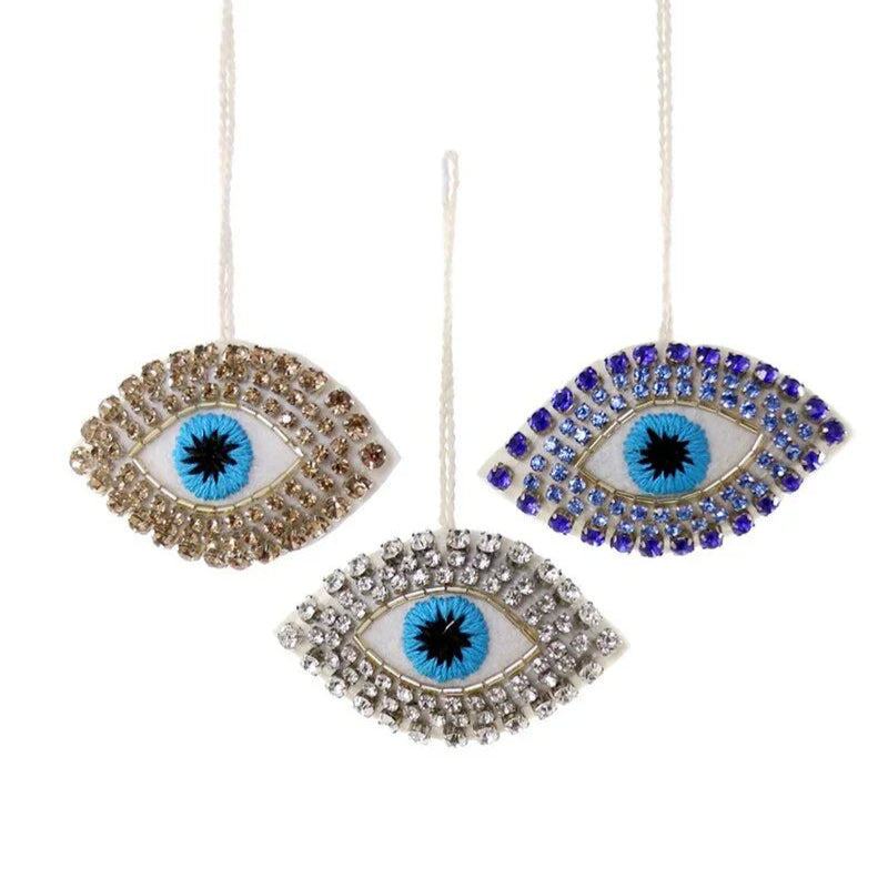 Three decorative evil eye ornaments with rhinestone embellishments on a white background