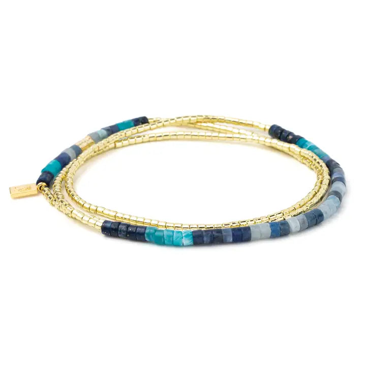 Multistrand bracelet with blue and gold beads on a white background