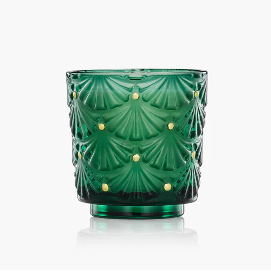 Voluspa Noble Fir Green glass candle with decorative pattern on a white background