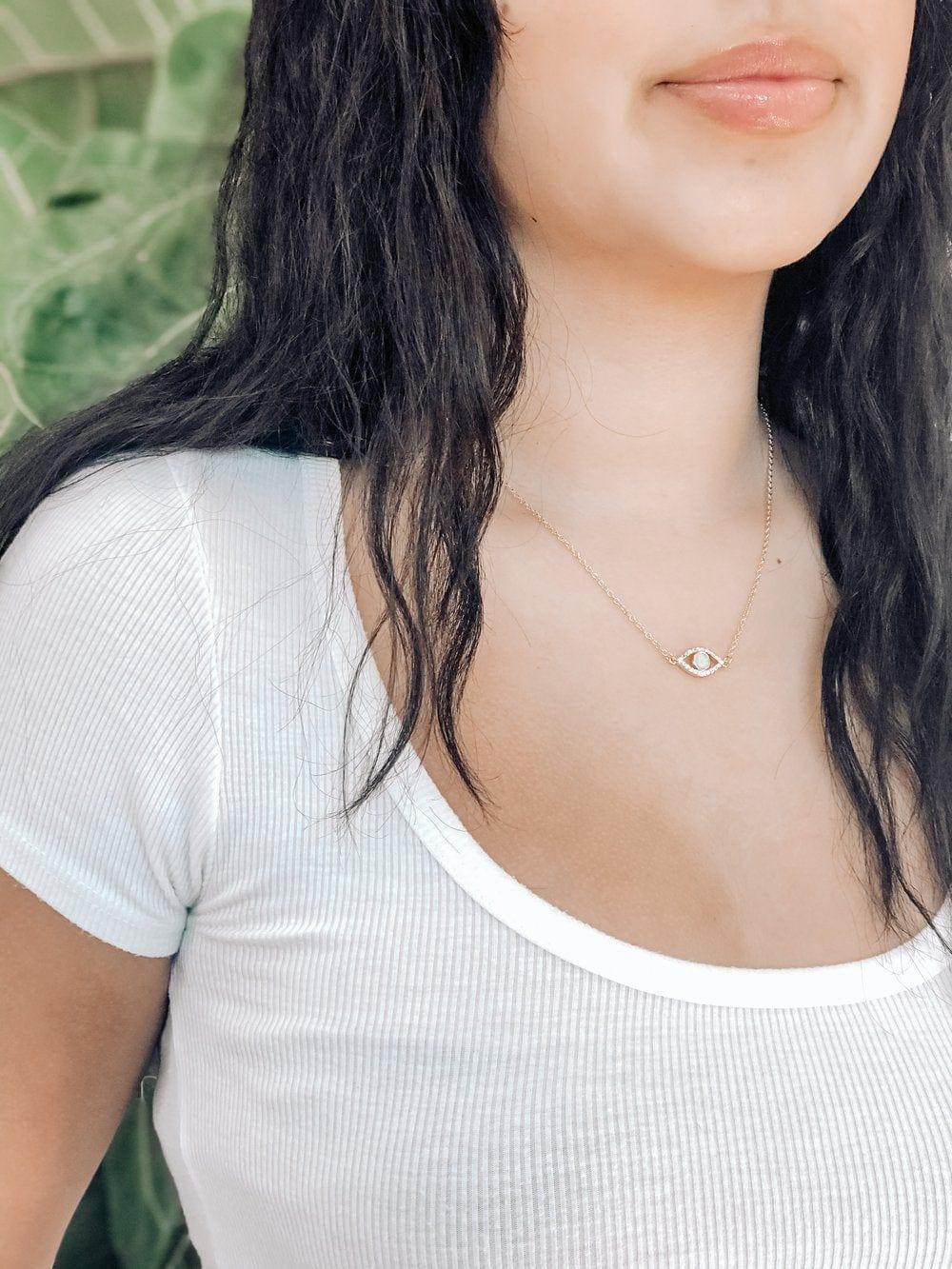 Young Woman With Dark Hair Wearing Pharauh's Evil Eye Necklace