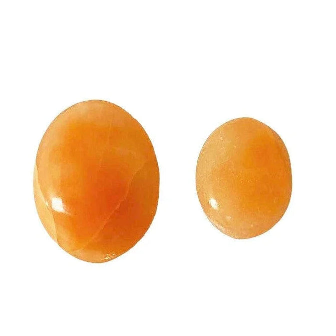 Two orange selenite stones on a white background