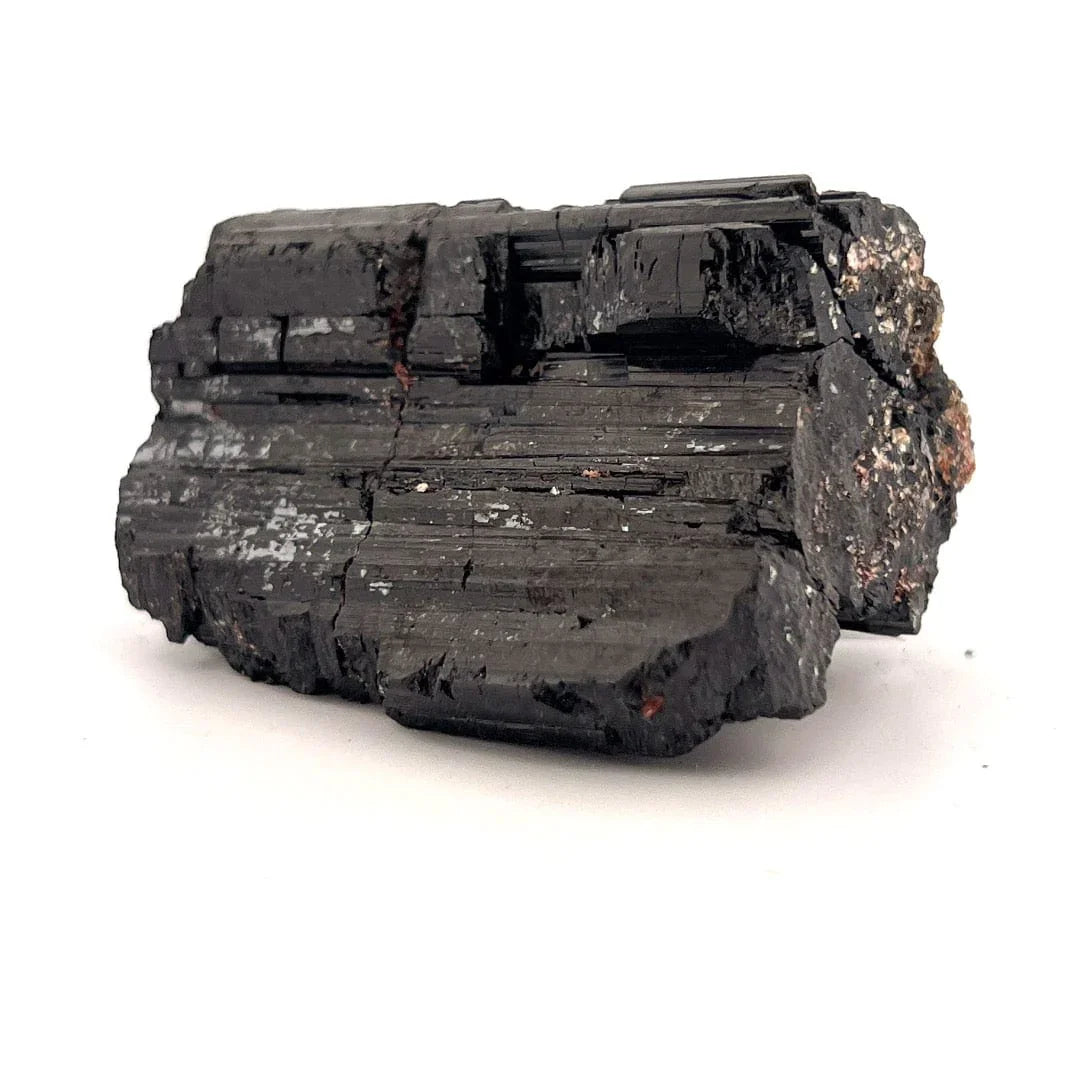 Stack of dark tourmaline stone blocks on a white background