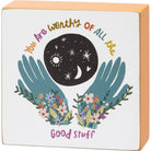 Decorative box with hands holding flowers, moon, and stars, and text 'You Are Worthy Of All The Good Stuff' on a white background.