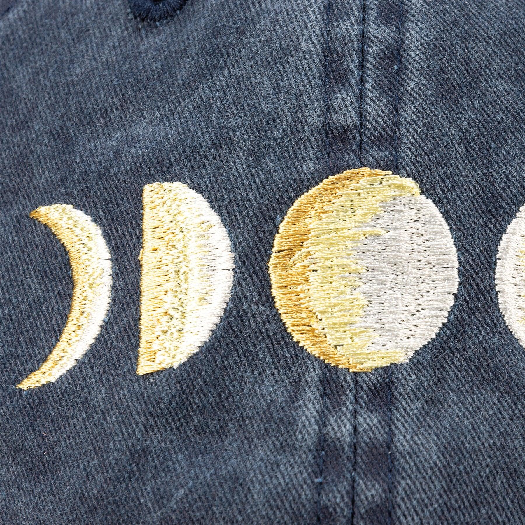 Embroidered moon phases on a denim jacket