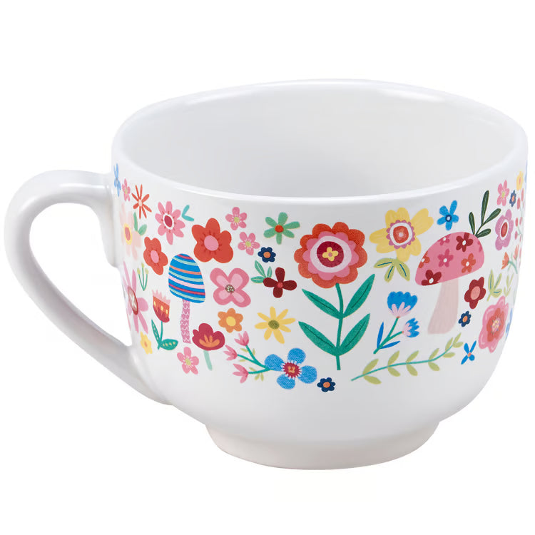 White mug with colorful floral and mushroom pattern on a white background