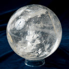 Clear crystal sphere on a dark blue fabric background