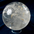 Clear crystal sphere on a dark blue fabric background