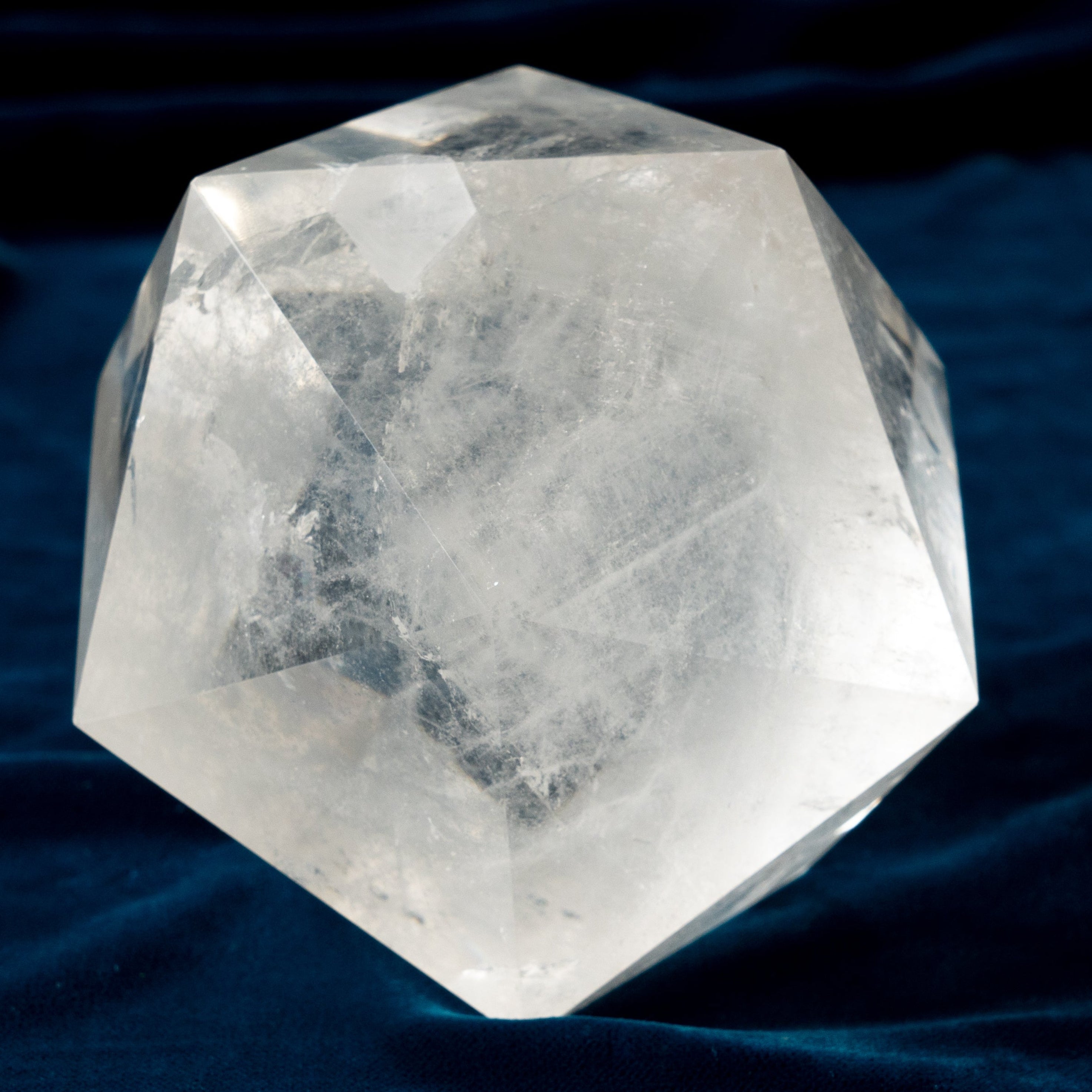 Clear crystal on a dark blue fabric background
