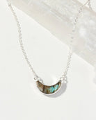 Necklace with a semi-circular Labradorite Eclipse pendant on a white background
