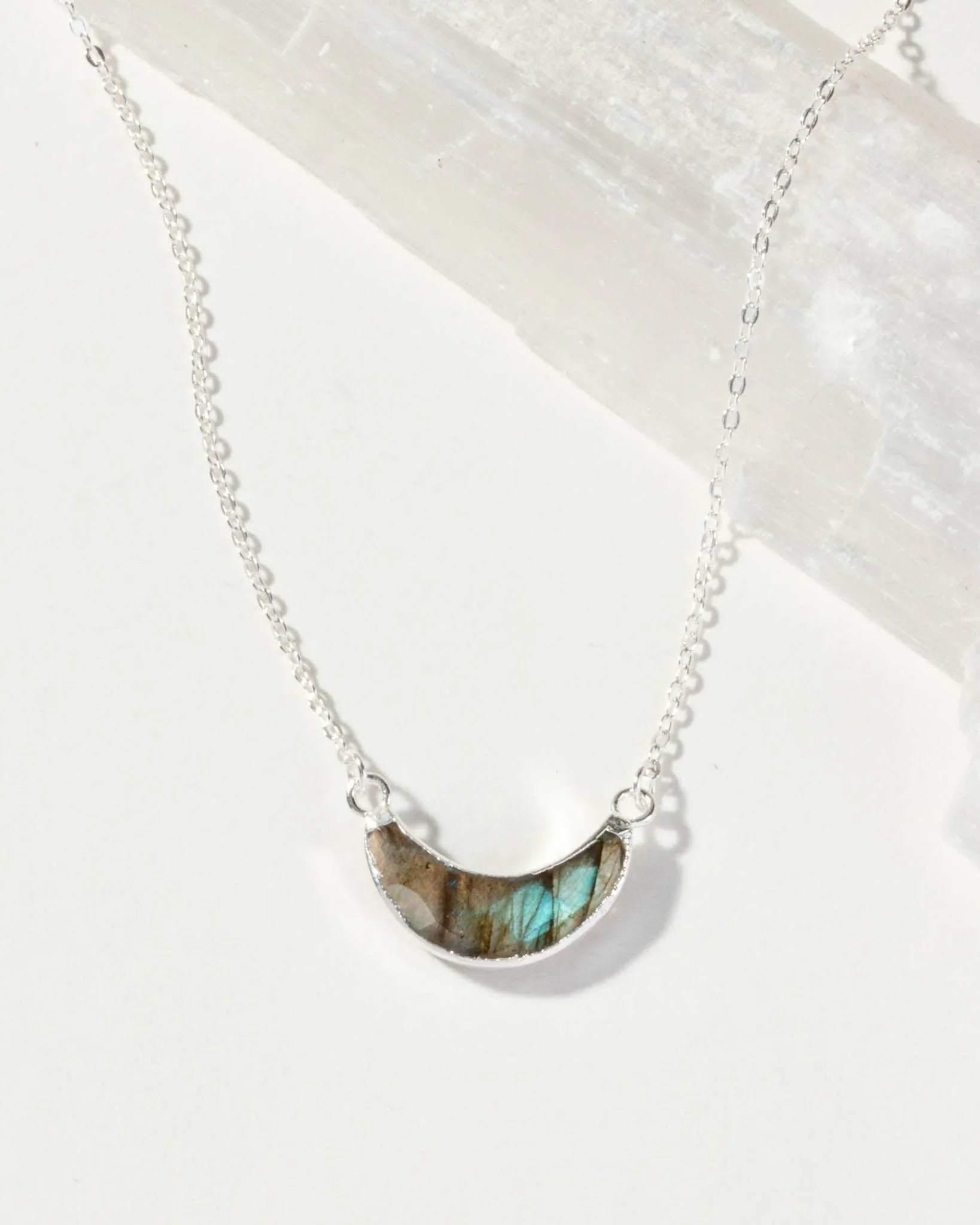 Necklace with a semi-circular Labradorite Eclipse pendant on a white background