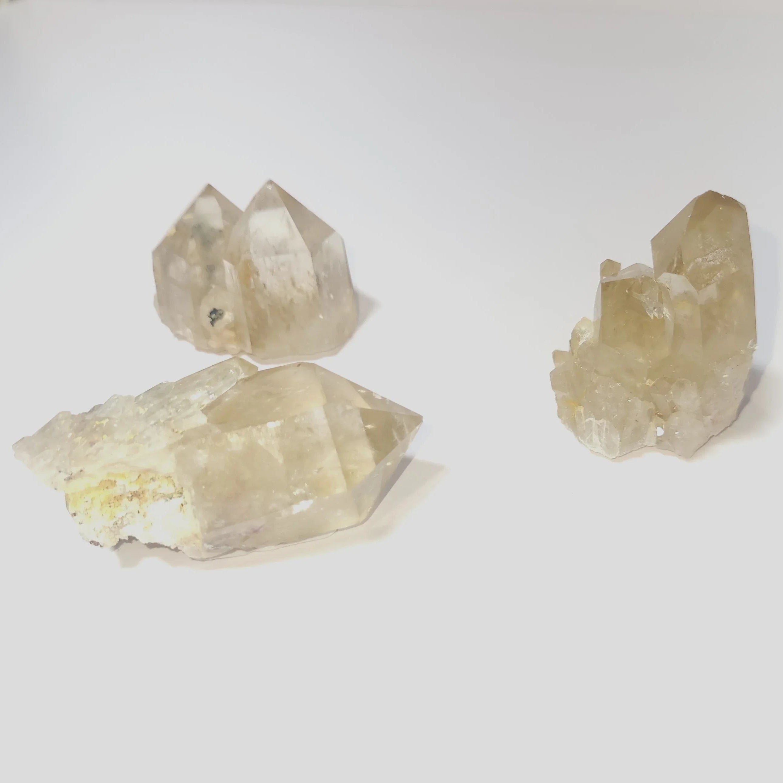 Three cKundalini Citrine Point Natural 100-600 grams crystal formations on a white background