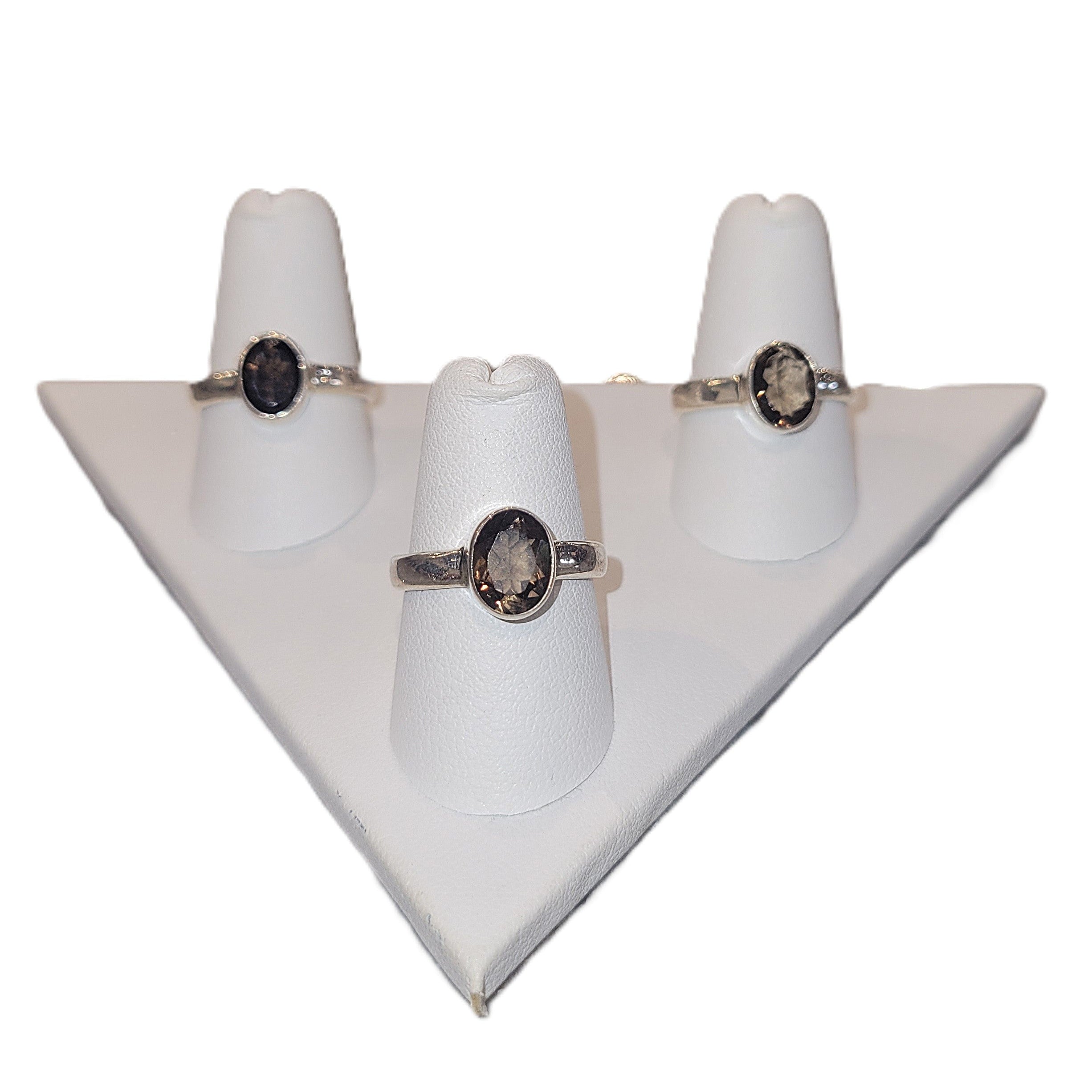 Three smoky quartz rings on white stands on a white background